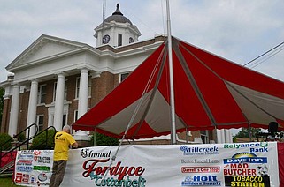 Fordyce on Cotton Belt Festival Director Mike Trammel secures the corporate sponsor banner to the Courthouse Square main stage in preparation for a full weekend of nationally acclaimed live music. (Special to The Commercial/Richard Ledbetter)